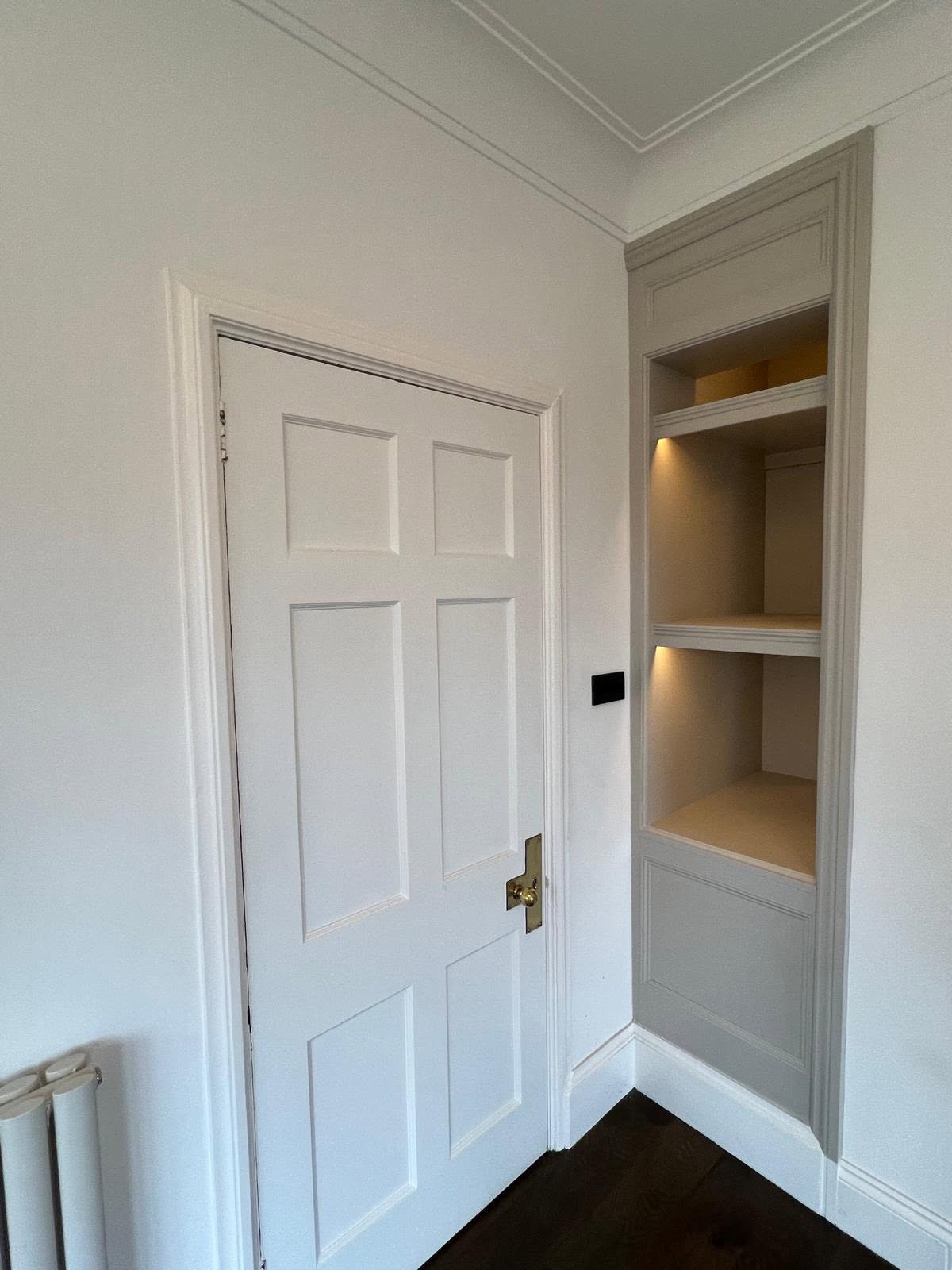 Built in taupe shelving unit with integrated warm spot lighting