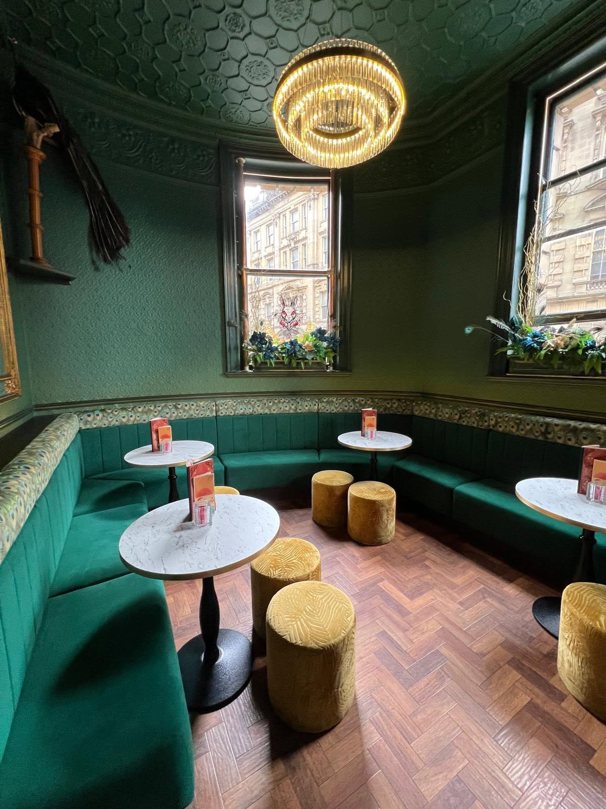 Emerald green room with peacock trim, embossed ceiling, ring chandelier and herringbone parquet