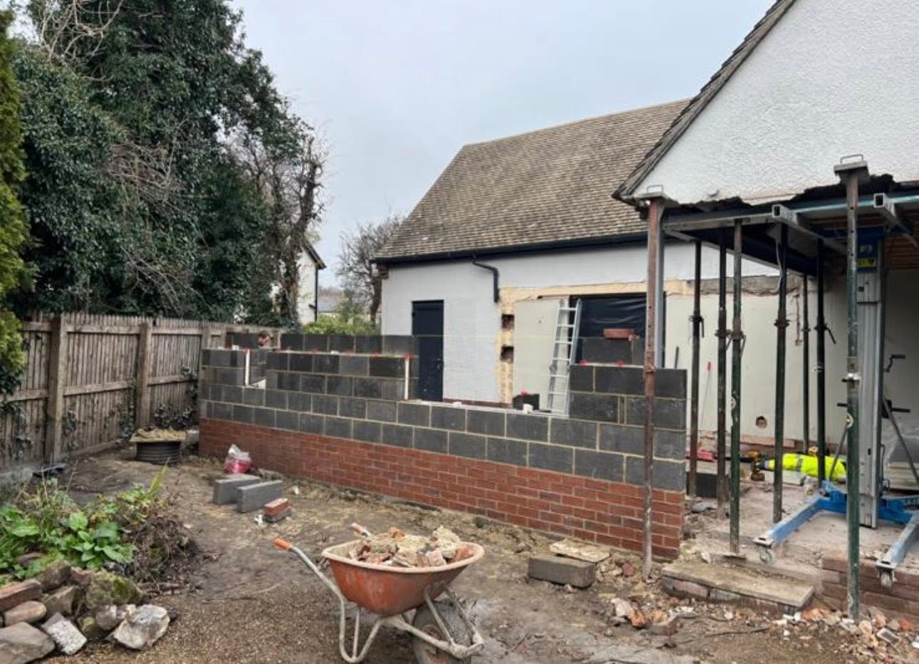 Progress shot of blockwork and brick cavity walls with acrow props supporting the existing structure