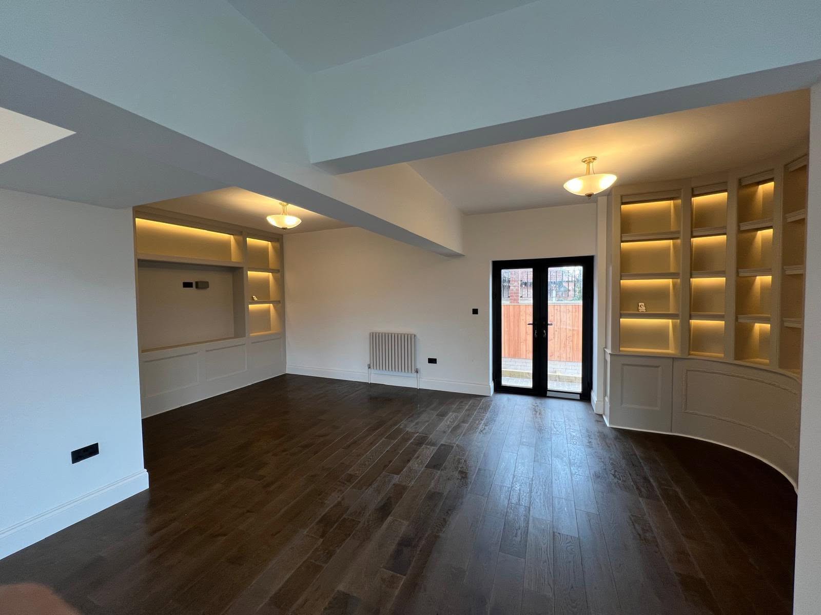 Media wall and curved backlit bookshelves in the Gosforth living space