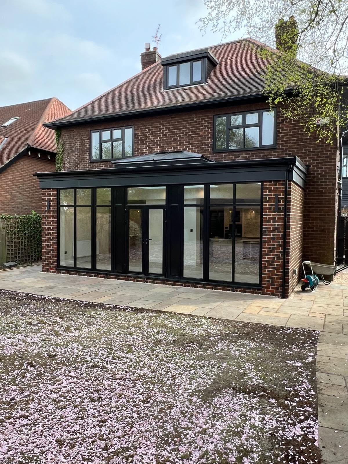 Rear elevation of a Gosforth house with a new black framed glass extension