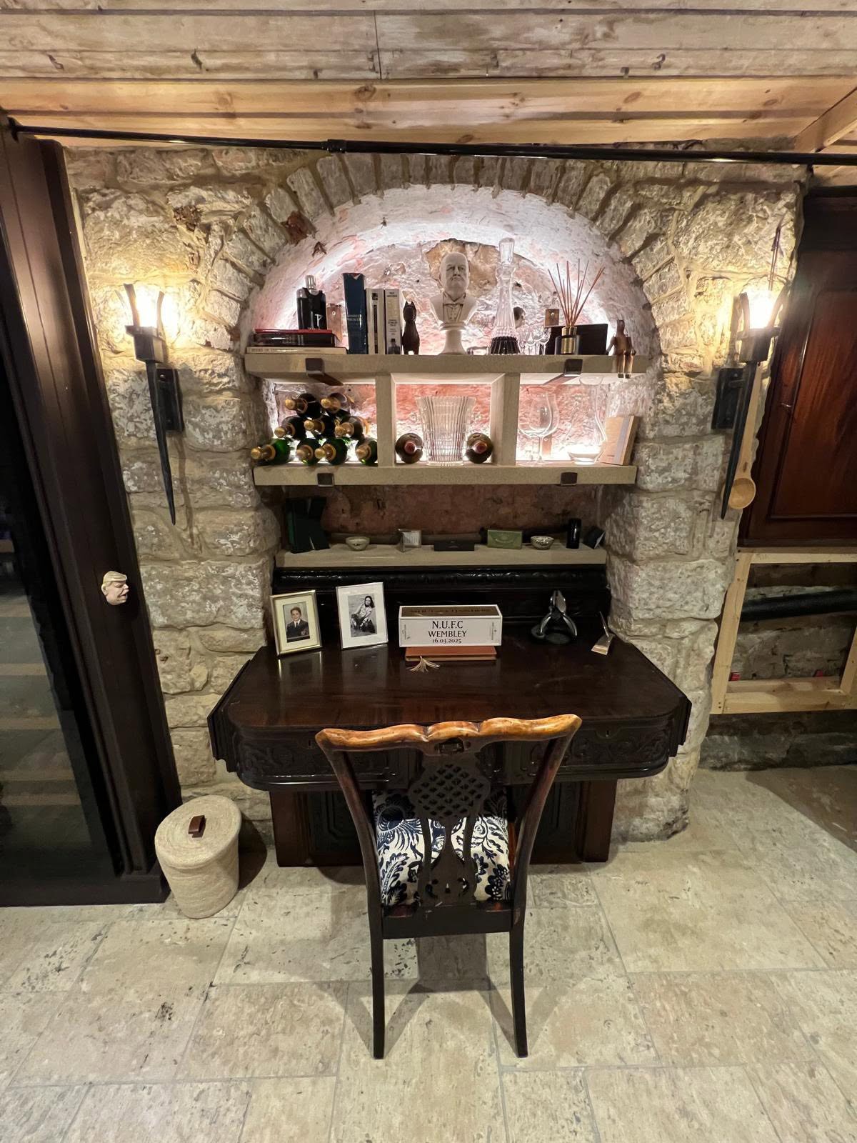 Alcove nook with lit stone shelving and champagne bottle rack