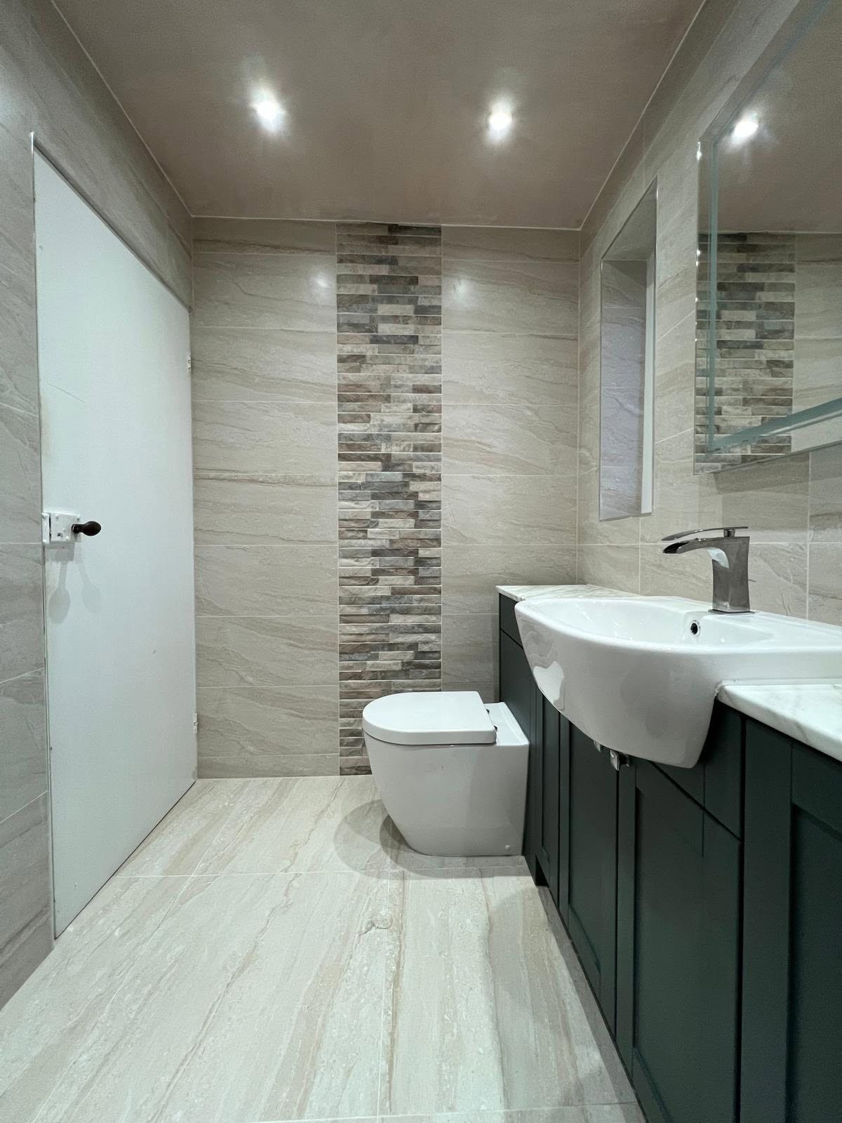 WC and basin run in the wet room with vertical mosaic feature band, back to wall WC and wall hung mirrors