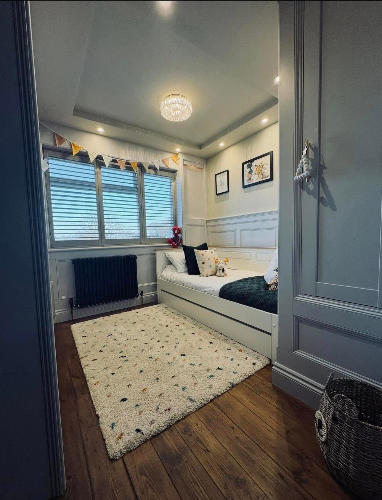 Panelled child's bedroom with fitted wardrobes and cabin bed