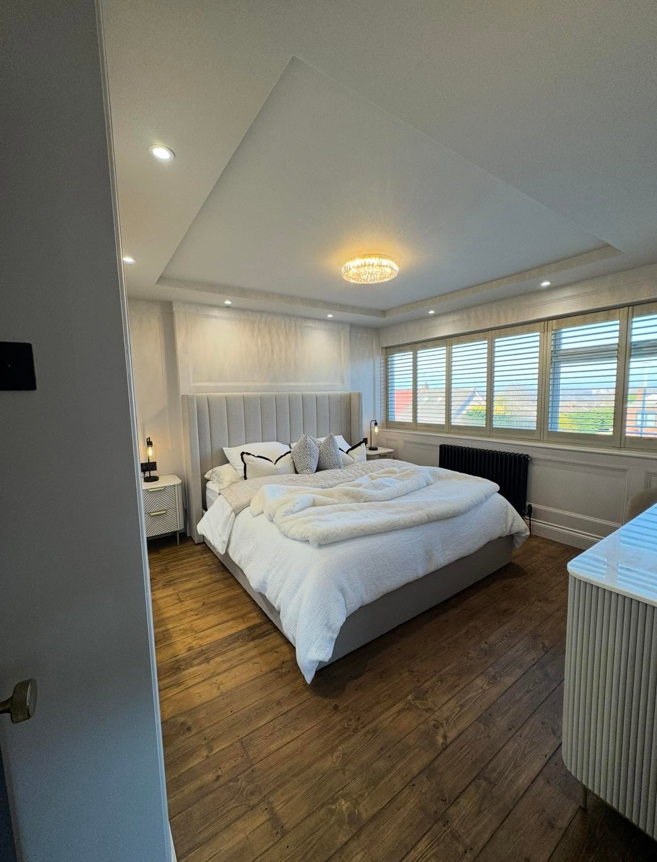 Master bedroom with recessed feature ceiling, concealed lighting, crystal flush pendant and dado wall panelling