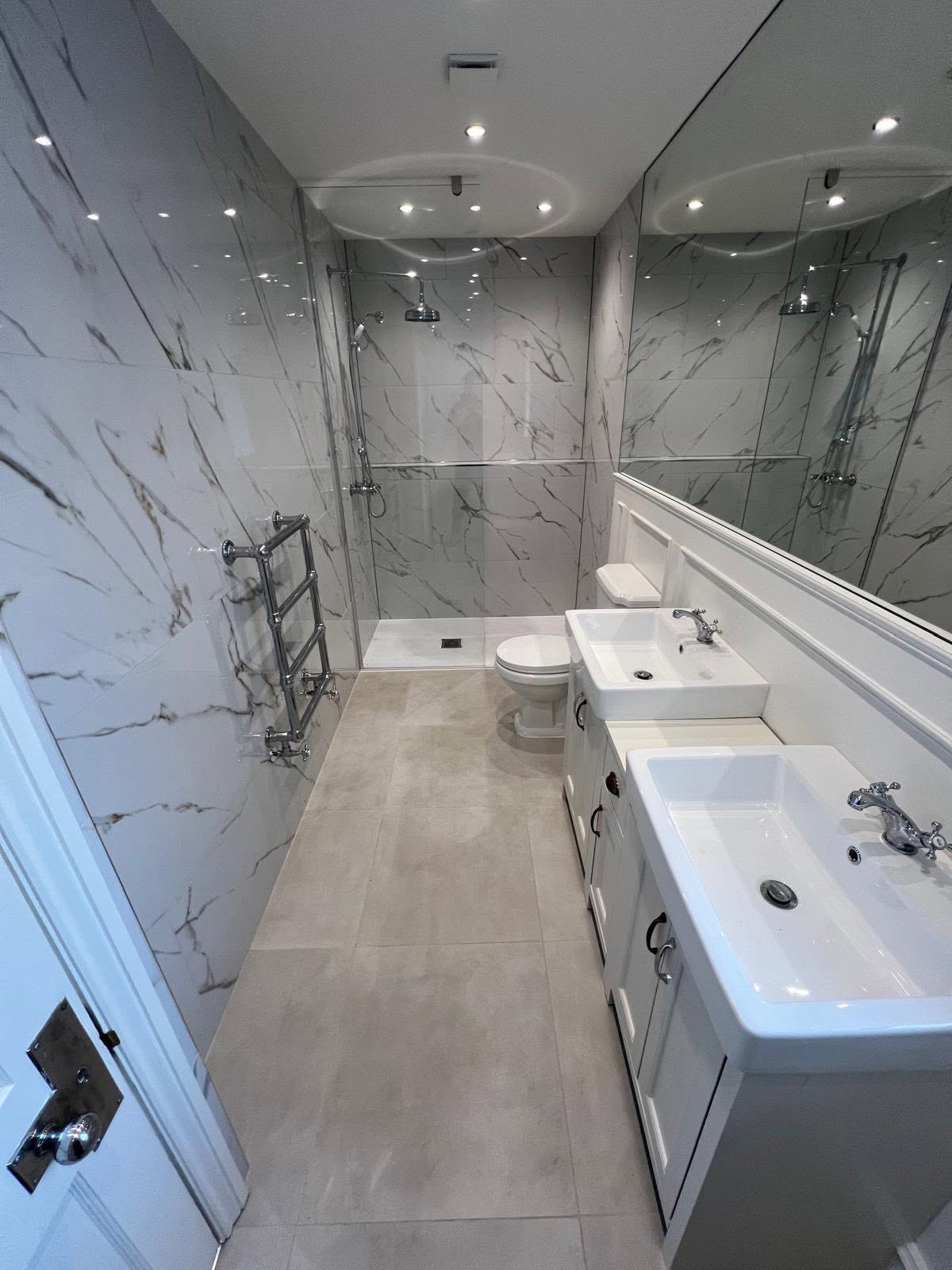 Narrow ensuite with marble walls, walk in shower and double vanity