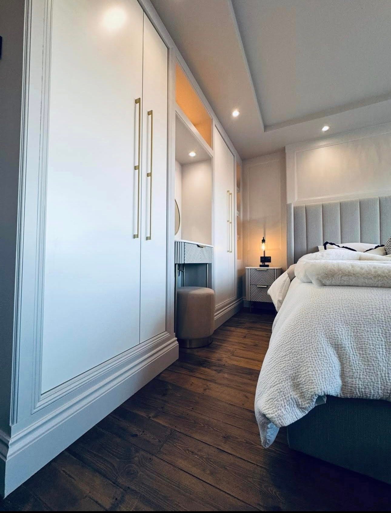 Detail of fitted bedroom wardrobes with brass handles