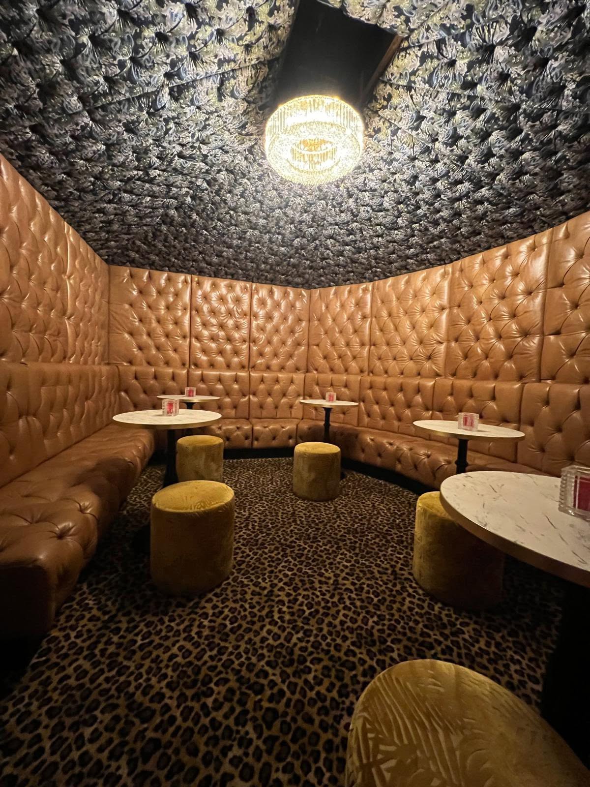 The Vault snug with tan buttoned-leather wall panelling, crystal chandelier and leopard carpet